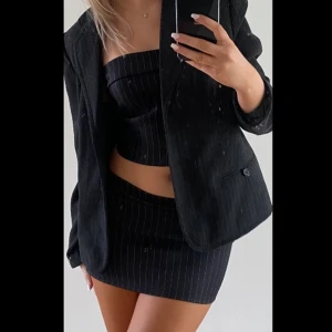 Tvådelat set  - Ett tvådelat set med en mini skirt och en bandeau topp. Säljer på grund av att kjolen är för kort. Aldrig använt. Nypris 270kr