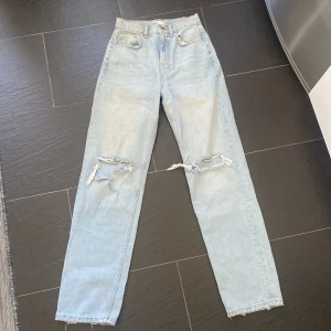 Jeans från Gina Tricot Stl 32 - Mycket fina ljusa jeans från Gina Tricot.  Knappt använda. Slitningar/hål på knän (från butik).