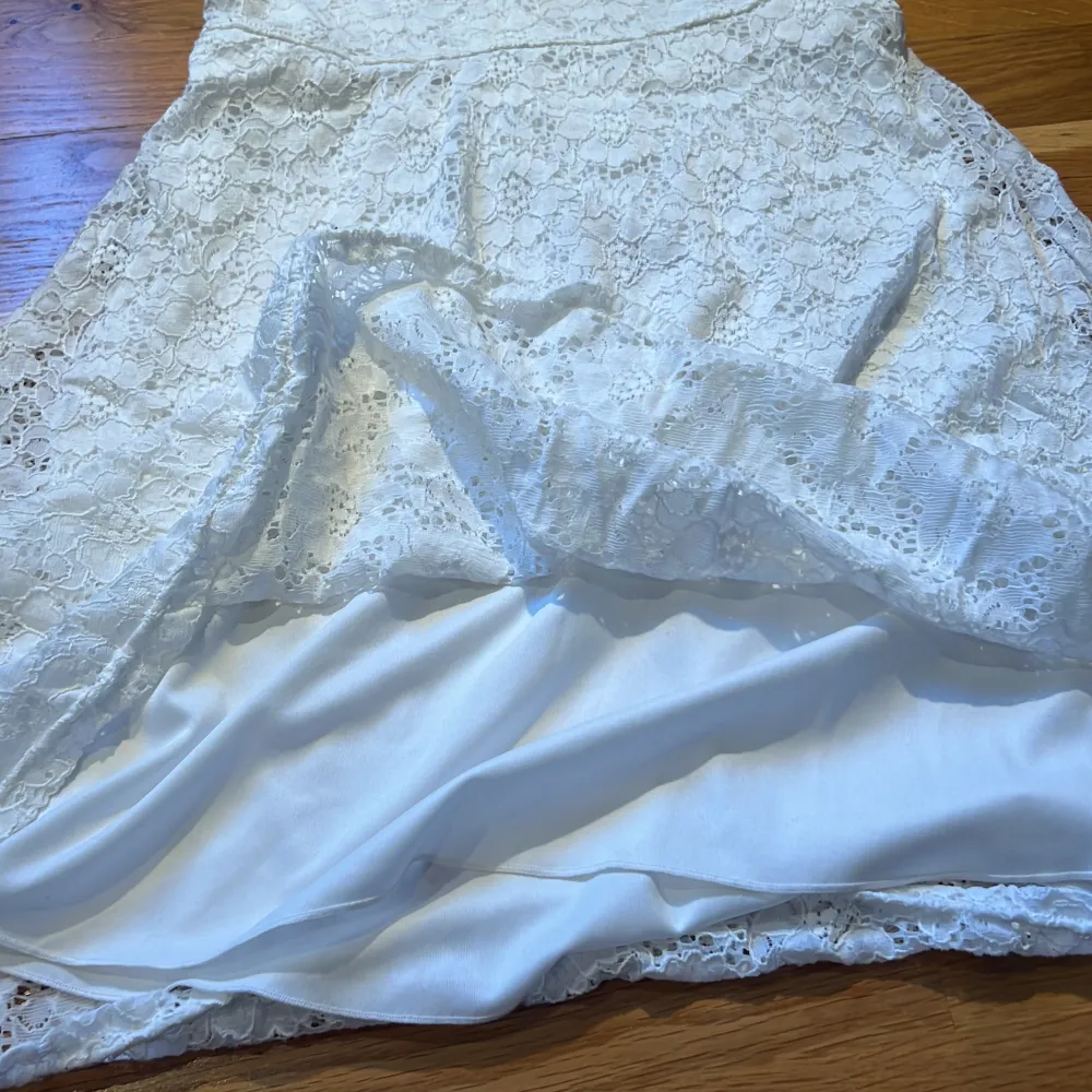 Det är en vit klänning med lite blomm aktigt mönster, original priset är 250 och är inte så använd. Silkes tyg inuti så dem är skön mot kroppen. . Klänningar.