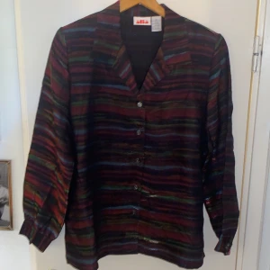 Glansig kavaj - Glansig kavaj i häftiga färger. Tyget är lätt och luftigt! Från Beyond Retro och aldrig använd. 