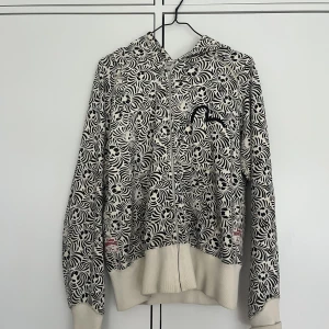 Evisu hoodie - Evisu hoodie från 2000-talet i mycket bra skick. Logga på bröst och rygg uppbyggt av dödskallar. Har varit mig trogen i många år men eftersom den är för liten för mig nu så hoppas jag att den kan få en ny ägare som uppskattar den lika mycket som jag gjort