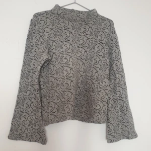 Grå stickad ulltröja med mönster - Stickad grå ylletröja med blommigt mönster.   Utsvängda ärmar.   Köpt second hand men gott skick 🤗 75% ull    Strl 38. Fast skulle säga liten i storleken, ffa på längden (i midjan), som 34/36