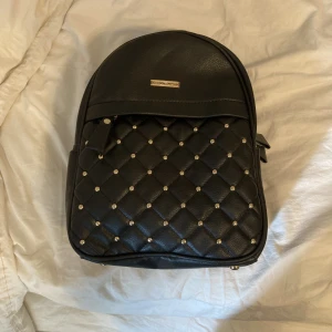 Ryggsäck  - Helt oanvänd ryggsäck med guld ditalger 