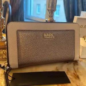 HELT NY, Äkta Karl Lagerfeld plånbok. Köpt för 2200kr, säljer den för 1500kr. Lyxig plånbok i riktig läder från Karl Lagerfeld! Färg: metallic Rose guld och beige. 💕