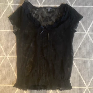 spetstopp - så fin spetstopp. har en gullig rosett vid urringning, och jättegulliga volanger. sp snygg med den genomskinliga svarta spetsen. 