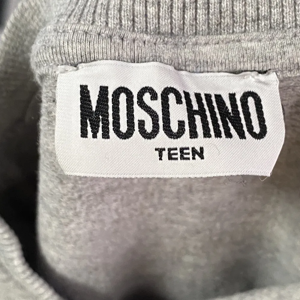 En väldigt skön Moschino tröja som är i väldigt gott skick köpt på kidsbrandstore ny pris 1200kr. Hoodies.