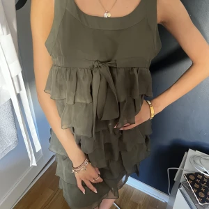 Volangklänning - En jätte söt olivgrön klänning med volang och en söt rosett man knyter vid bysten! Jättesnygg i sommar och kan andvöndas till vardags och både fest!❤️‍🔥❤️‍🔥❤️‍🔥