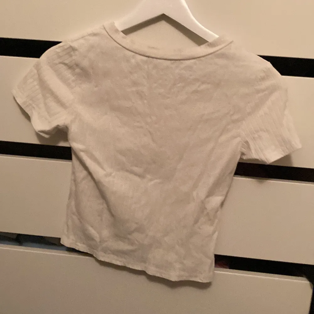 En basis vit T-shirt, ribbad med v krage, inget tecken på användning . T-shirts.