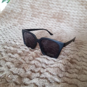 Solglasögon - Svarta solglasögon. Tidlös modell med svart glas. Uv 400