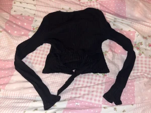 topp - en svart topp med en knut i ryggen 