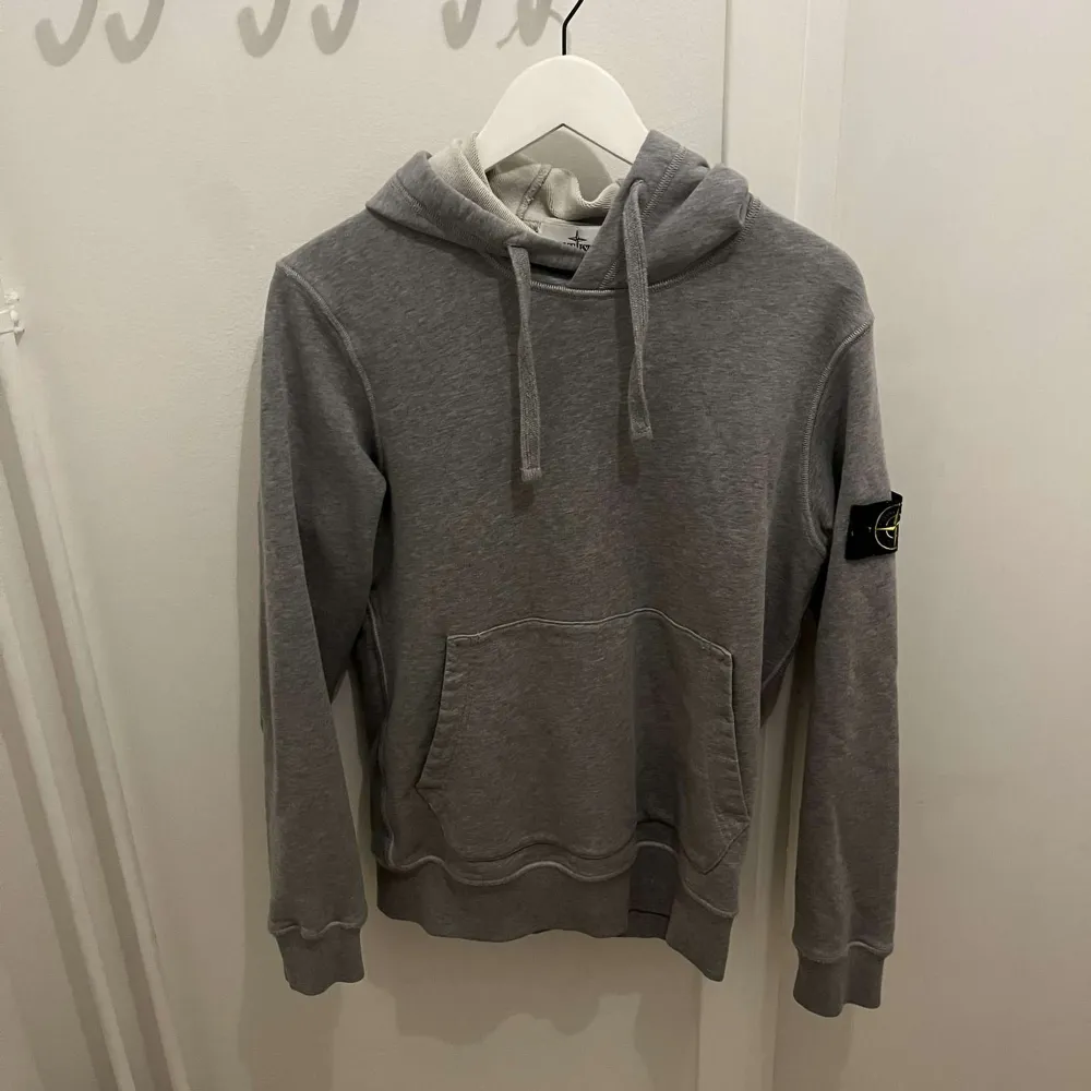 En grå Stone island hoodie som är i mycket bra skick. 8,5/10. Köpt på Nk i Stockholm . Hoodies.