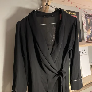 Skjorta med vita detaljer på ärmarna  - Skjorta med vita detaljer på ärmarna   Kort i modellen. Fint skick 