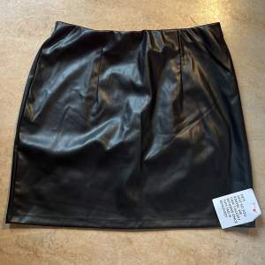En svart kjol i läderimitation och storlek UK 10 / EU 36 från ASOS. Inte använd och är som helt ny. 