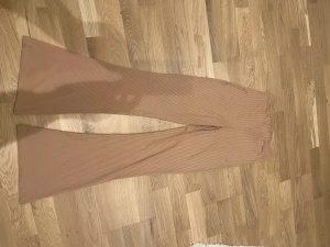 Utsvängda leggings strl s beige/rosa - Fina utsvängda leggings  Storlek s men kan även bäras av en som bär m Har några små fläckar som förekommit när den legat i papperskasse i förrådet, tror det försvinner i tvätten därav priset
