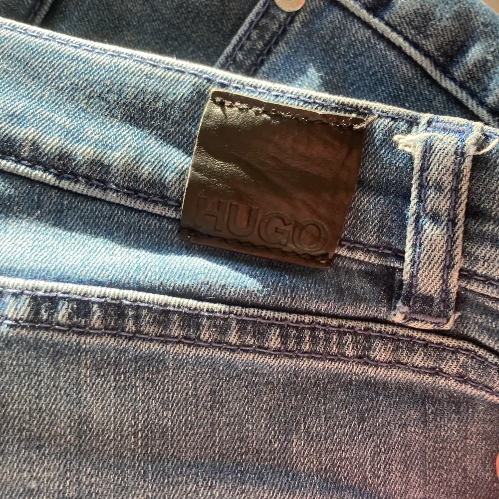 Säljer nu mina Hugo boss jeans pga av de är för små för mig. Dem är i storlek 29/34 och sitter som slim fit, avklippta vid slutet av benen men kan fixas genom att sy, sköna  dem är i bra skick förutom några ”plast” lappar i byxorna har lossnat lite.. Jeans & Byxor.