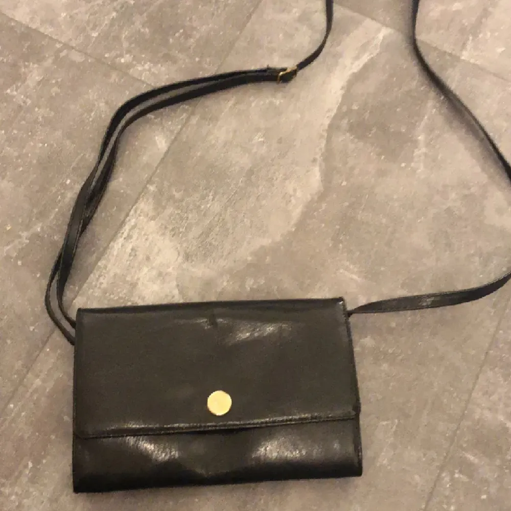En liten handväska som man kan ha över axeln, det går att ändra långden på snöret. Perfekt att ha mobil små saker i.. Väskor.