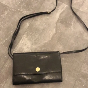 Väska - En liten handväska som man kan ha över axeln, det går att ändra långden på snöret. Perfekt att ha mobil små saker i.