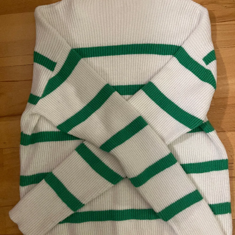 Vit stickad tröja med gröna streck från VILA. Fint skick. Den är lite högre vid nacken än vad det brukar vara. Den är lång i armarna och är lång i själva tröjan också så är perfekt nu till vintern för att hålla sig varm. Skriv för frågor och bilder🫶. Tröjor & Koftor.