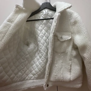 Vinterjacka - Vit vinterjacka. Använd 1 gång. Varm och vadderad.