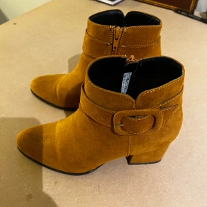 Stövletter  - Mörkgula stövletter som använts ett fåtal gånger. 