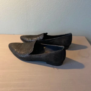 Skor Filippa K, str 40 - Svarta, svagt glittriga loafers från Filippa K. I princip oanvända och i mycket fint skick. 