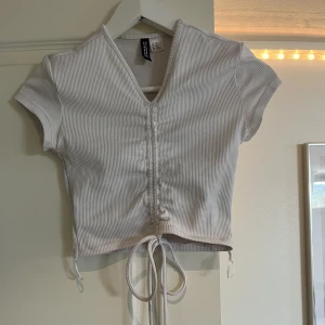 Vit tirsurt  - En tirsurt me snören längst ner som man knyter runt🙌🏻 jätte bra skik 💓 OBS ❌ det är en liten fläk längst upp på tröjan. Men inget man tänker på.☺️