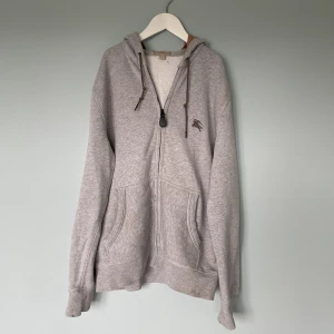 Burberry zip hoodie L - Säljer nu denna snygga zip hoodie ifrån Burberry som är perfekt inför hösten och är i storlek L | Skick: 7/10 alla defekter syns på bilderna | Nypris: 6000 kr | Budgivningen kickar igång på 1 kr | Hör av er vid minsta fråga eller fundering :)