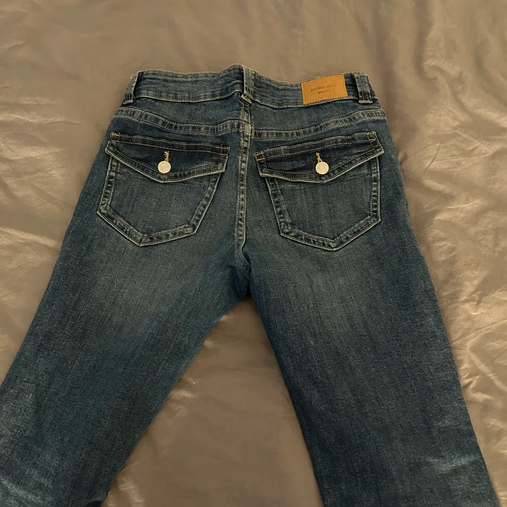 Low waist bootcut jeans med knappar på bakfickorna super snygga tyvärr för stora för mig Storlek 36. Jeans & Byxor.