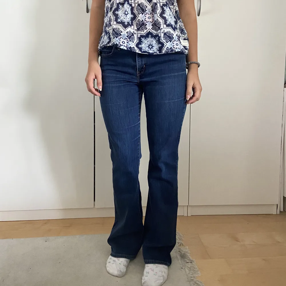 Lågmidjade bootcut levi’s jeans i en mörkblå färg. Modellen är 165cm lång. . Jeans & Byxor.