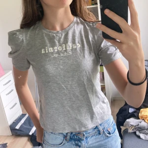 Grå gammal HM T-shirt  - En grå blus från HMs barnavdelning. Inte använd på flera år. Passar dig som vanligen har stl s också. I priset ingår ej frakten. 