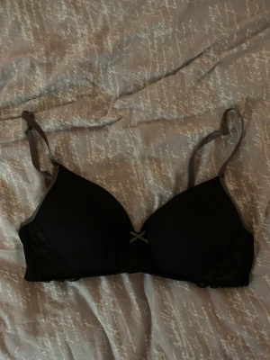 Svart bh - Svart och grå bh med detalj i spets på sidorna. Använt skick men fortfarande fullt användbar och inga defekter.