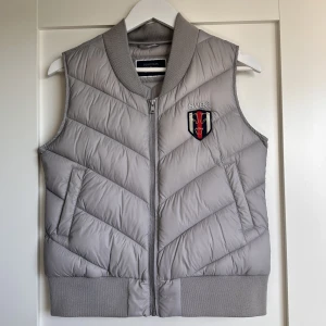 Grå dunliknande väst - Säljer denna gråa dunliknande väst ifrån equestrian by Svea❤️Passar lika bra till stan som i stallet. Använda fåtal gånger och skicket är som nytt. Storlek: S. Pris 150 kr + frakt. Samfraktar gärna!