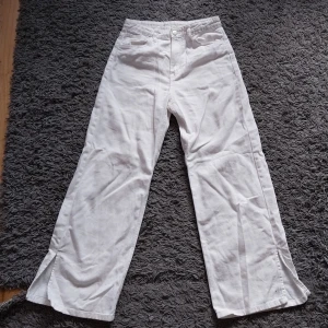 Vita utsvängda Jeans  - Vita utsvängdajeans med en liten slitz på byxbenen. Storlek 146.  Hög midja. Sparsamt använda.   Betalning sker via swish och köparen står för frakten.