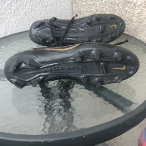 Nike tiempo fotbollsskor  - Svarta o guldiga fotbollsskor. De är 44 men känns som lite mindre. Dem e lite creasade men funkar perfekt.