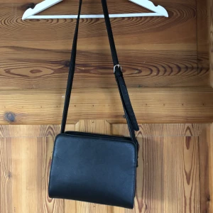 Svart axelremsväska  - Svart axelväska med flera fack. Den är sparsamt använd. Tyvärr vet jag ej märket.  Frakten ingår i priset 💙