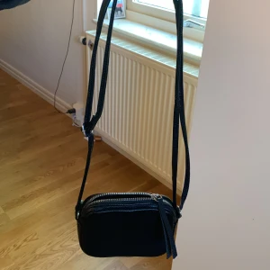 Väska - Fin, liten väska. Vet inte varifrån den är. Aldrig använd. Bandet går att göra längre och kortare. 