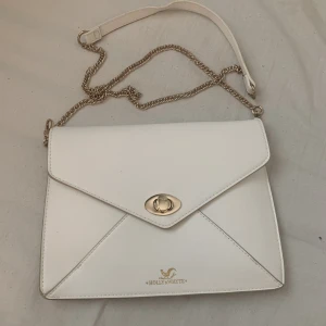 Axelväska  - En axelväska från Holly&whyte vit väska med guld kedja badvänligt nåra gånger därför jag säljer den