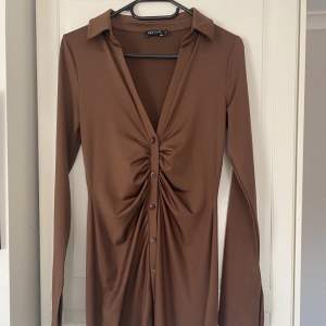 brun klänning med en liten slits i armen , 60kr+frakt , aldrig använd 