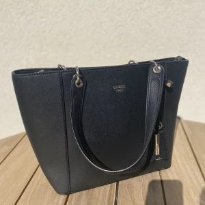 Guess handväska - Mått: 29 cm längd, 14cm bredd, 26cm höjd💕 Använd en gång!