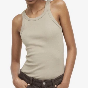 Ribbad topp - Ribbad gråbeige topp från H&M i storlek S. Aldrig använd utan bara testad. Materialet är jättemjukt och skönt! Ljuset är dåligt på den andra bilden så den ser mörkare ut än var den är i verkligheten. 