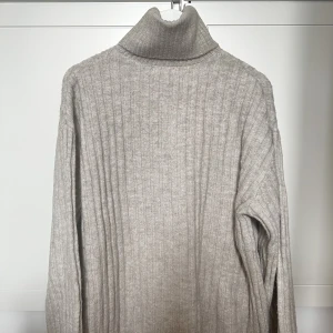 Stickad tröja  - Nästan oanvänd, så den är i mycket bra skick. Modellen är lite längre. Materialet är inte stickigt. 