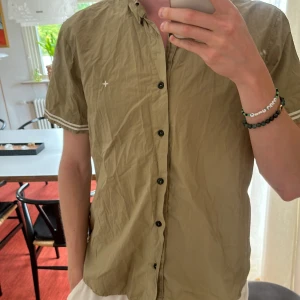 Stone Island Skjorta - Säljer en Stone Island skjorta i Storlek XXL. Skjortan är i mycket bra skick och endast använd ett fåtal gånger. Skulle säga 9/10. Köptes in för 2000kr från terrace.se. Tröjan har en olivgrön färg och passar till i princip allt.