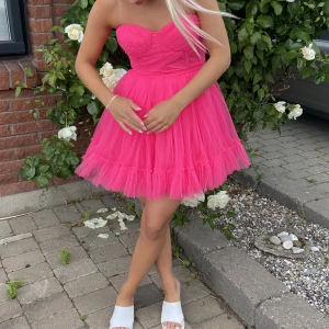 Rosa klänning - Drömmig klänning i chock rosa med tyll. Använd en gång. Storlek 38 men liten i storlek så passar 36. Köpare står för frakt! 