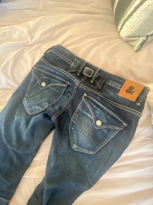 Jeans med fickor  - INTRESSEKOLL på dessa unika jeans. Köpt på second hand. Sitter bra på en med strl 34/36. Jeansen är låg midjade & straight leg. Sjukt snygga men får tyvärr inte mycket användning av det, där av annons. Bra skick. Kom privat för bild.Priset kan diskuteras💞