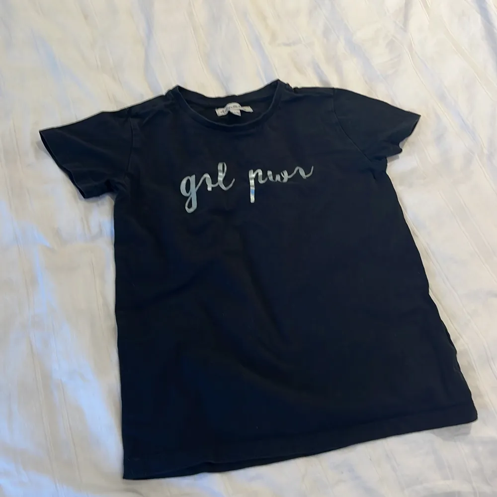 En basic svart tröja med text på, kortärmad och skön kvalitet och tvättas innan skick. T-shirts.
