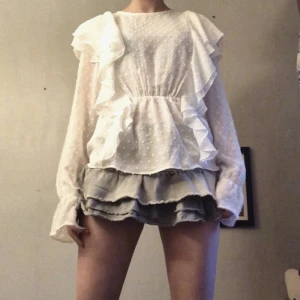 Blus - En vit blus ifrån Nly med volanger på, är i helt okej skick förutom några lösa trådar som jag hittade längst ner(jag har klippt bort de). Materialet är tunt så är perfekt nu när det är varmt! Kontakta mig vid intresse eller om du har några frågor💕