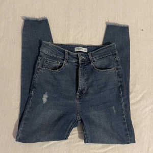 Pull&bear jeans - Högmidjade jeans i storlek 36, avsmalnade ben. Väldigt stretchiga, sitter perfekta i längd på mig som är 160 cm. Använda fåtal gånger.