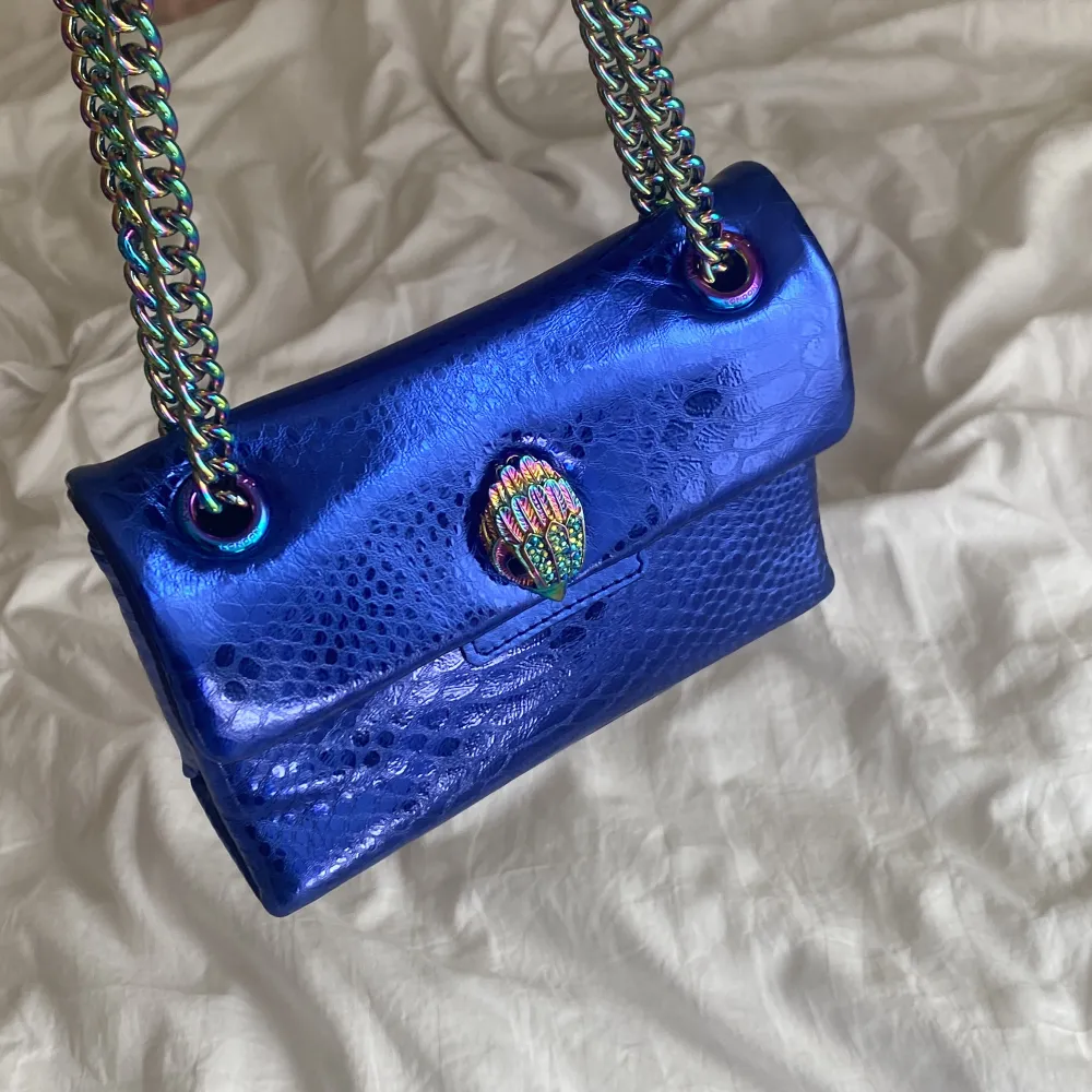En blå väska från kurt geiger i den lilla modellen. Väskan är i väldigt bra skicka och har använt den ett få antal gånger. . Väskor.