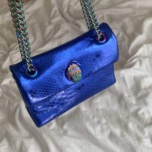 En blå väska från kurt geiger i den lilla modellen. Väskan är i väldigt bra skicka och har använt den ett få antal gånger. 
