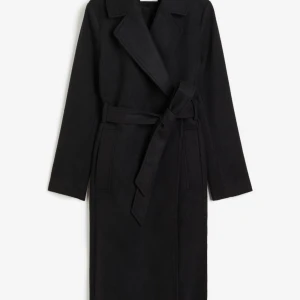 Svart kappa - Svart kappa från hm storlek 42 använd under våren, fint skick, vissa ställen nopprig.